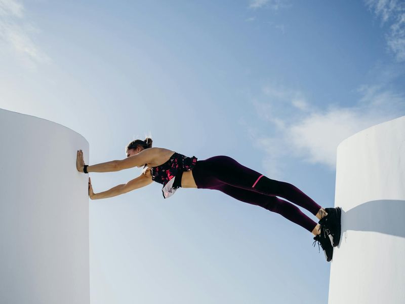 Man performing a controlled bodyweight exercise in a minimalist setting.
